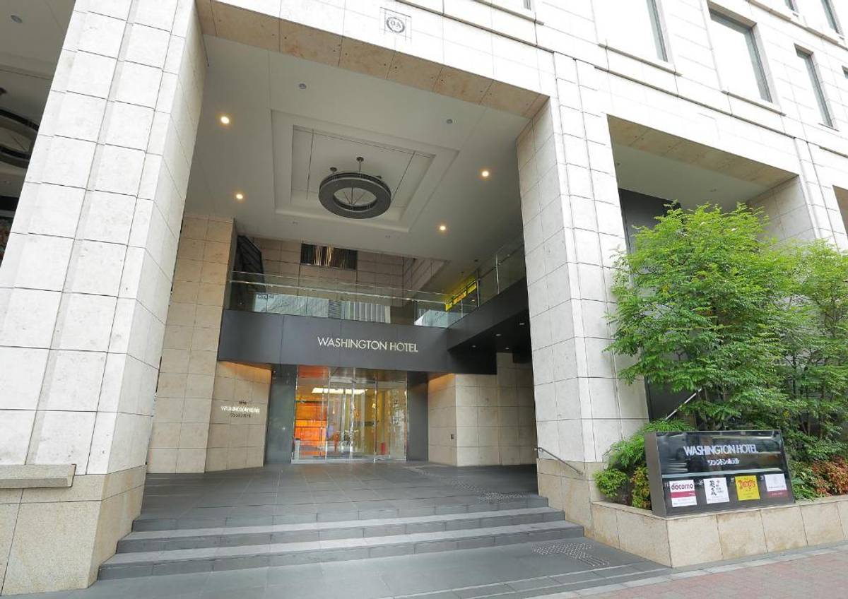 Entrance to a modern Washington Hotel building with a revolving door and steps.
