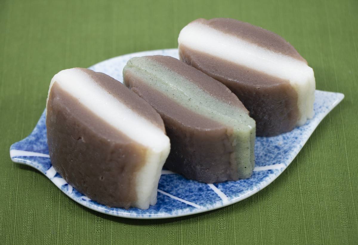 Three layered wagashi on a leaf-shaped blue and white plate.