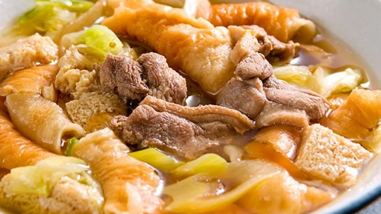 a close up of a bowl of soup with meat and vegetables .