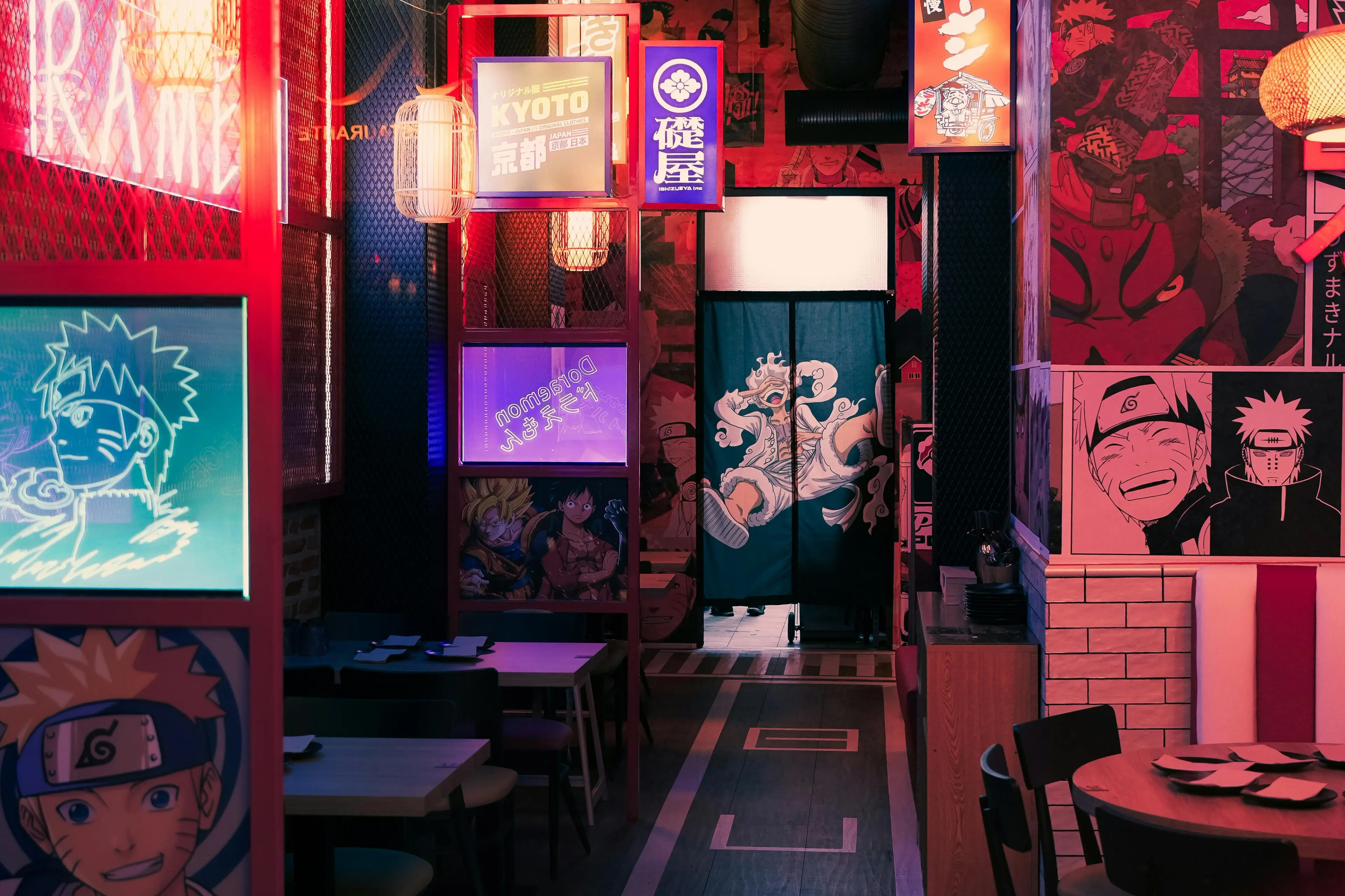 Vibrant anime-themed restaurant interior with Naruto, One Piece, and Dragon Ball decor, red neon lighting, and dining tables.