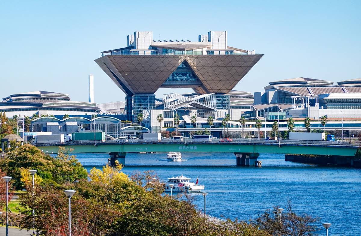 Tokyo Big Sight behind a river and bridge with boats.