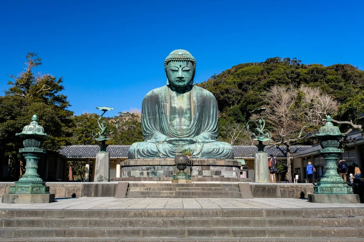 Large bronze Buddha statue under clear blue sky.