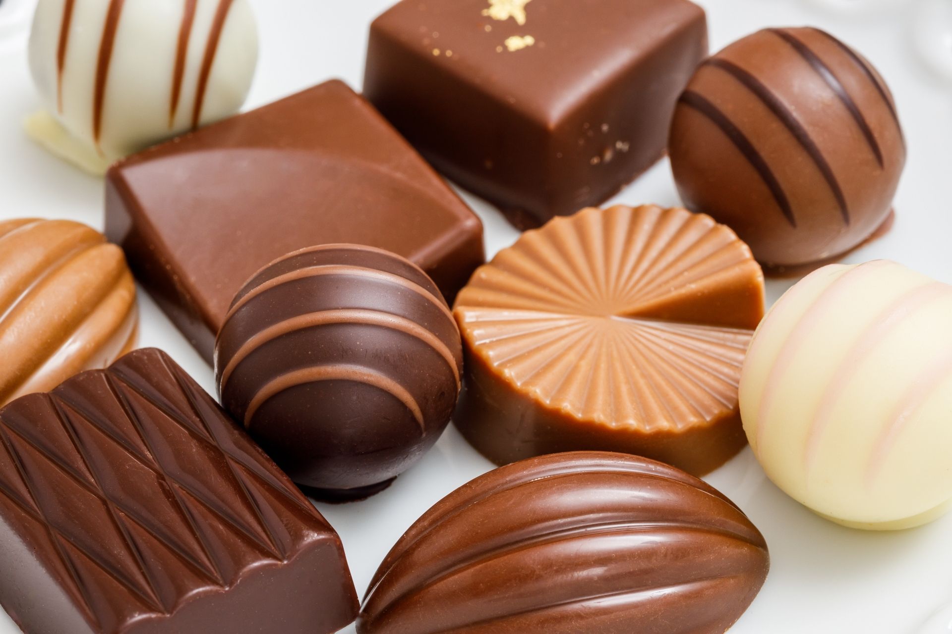 Assorted chocolates in various shapes and shades of brown and white.