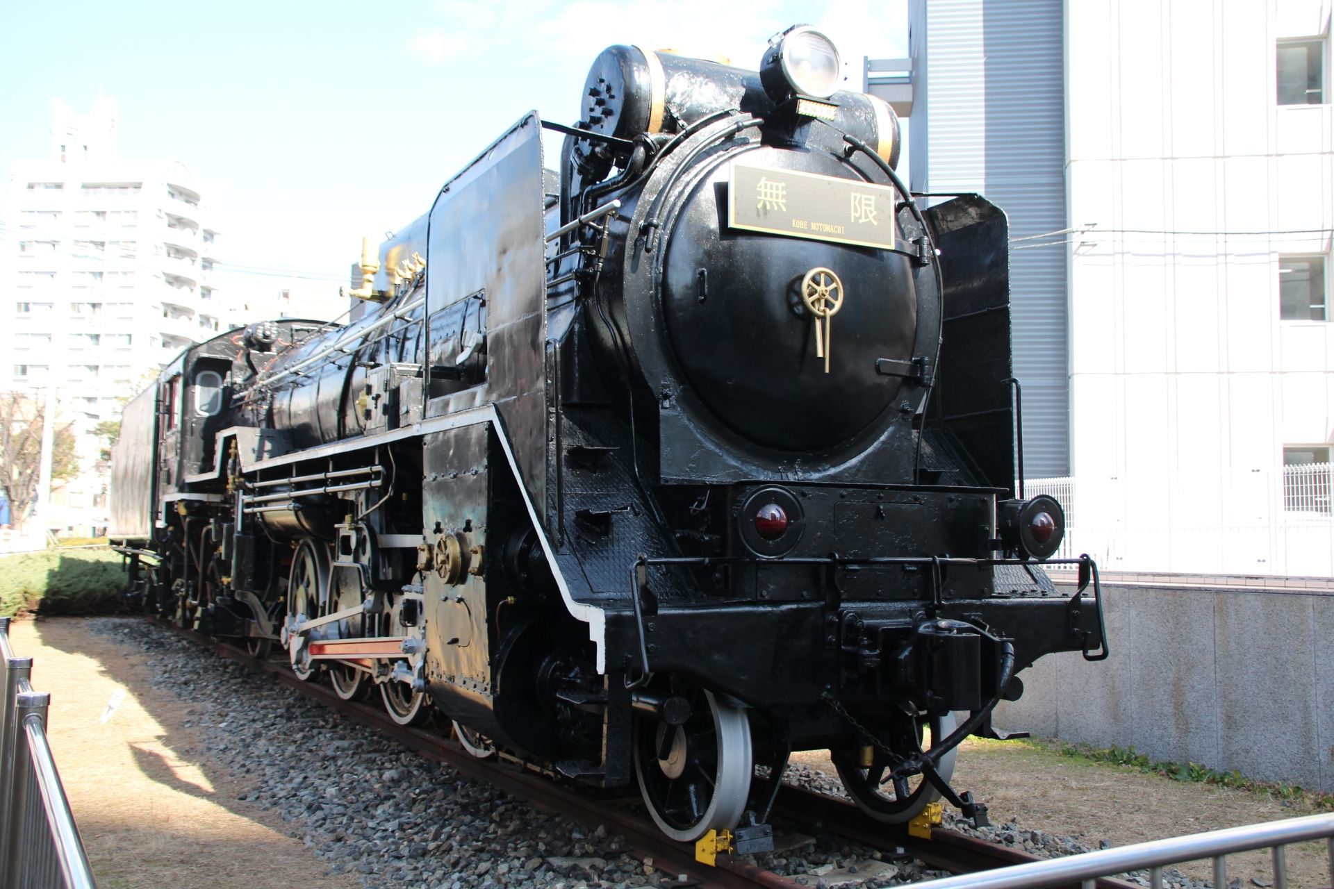 A black steam locomotive with a gold "無限" (Mugen) nameplate on the front.