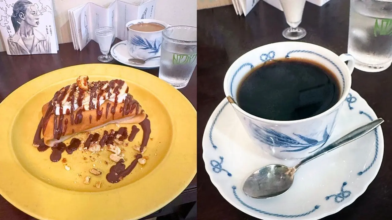 A dessert crepe with chocolate, whipped cream, and nuts on a yellow plate, next to a cup of black coffee.