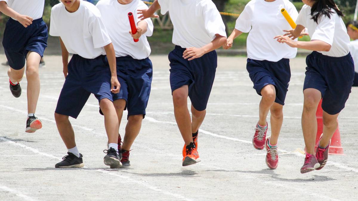 Students running a relay race, with batons being passed between them.