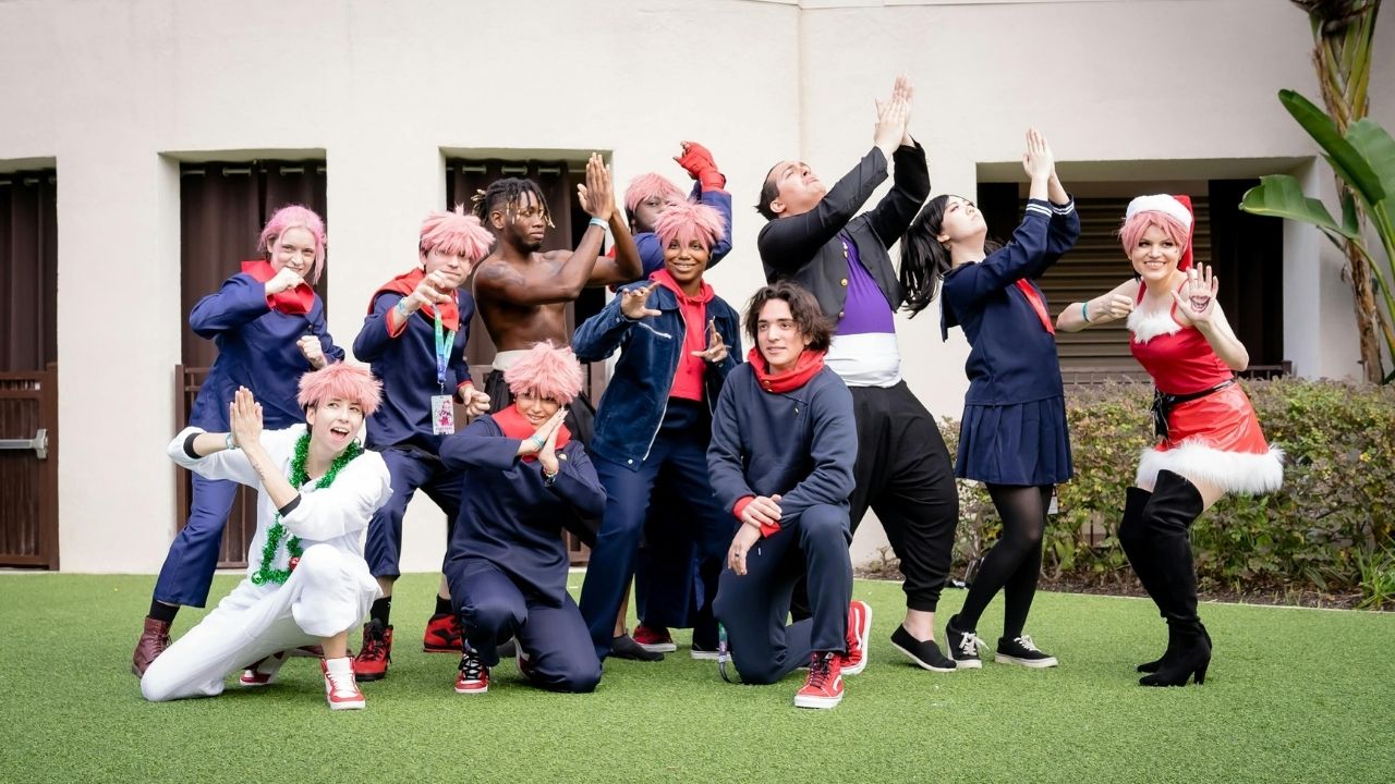 A group of cosplayers, including multiple Itadori Yuji variations and a Santa, pose dynamically outdoors.