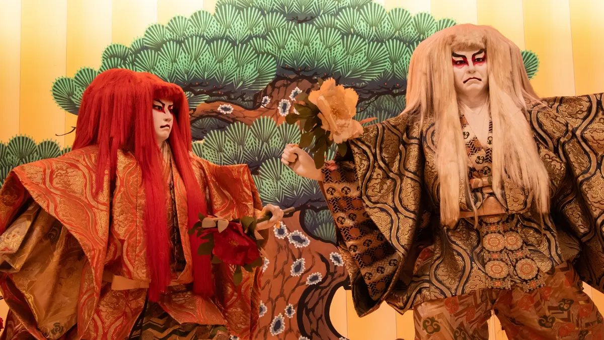 two men in traditional costumes are standing next to each other in front of a pine tree .