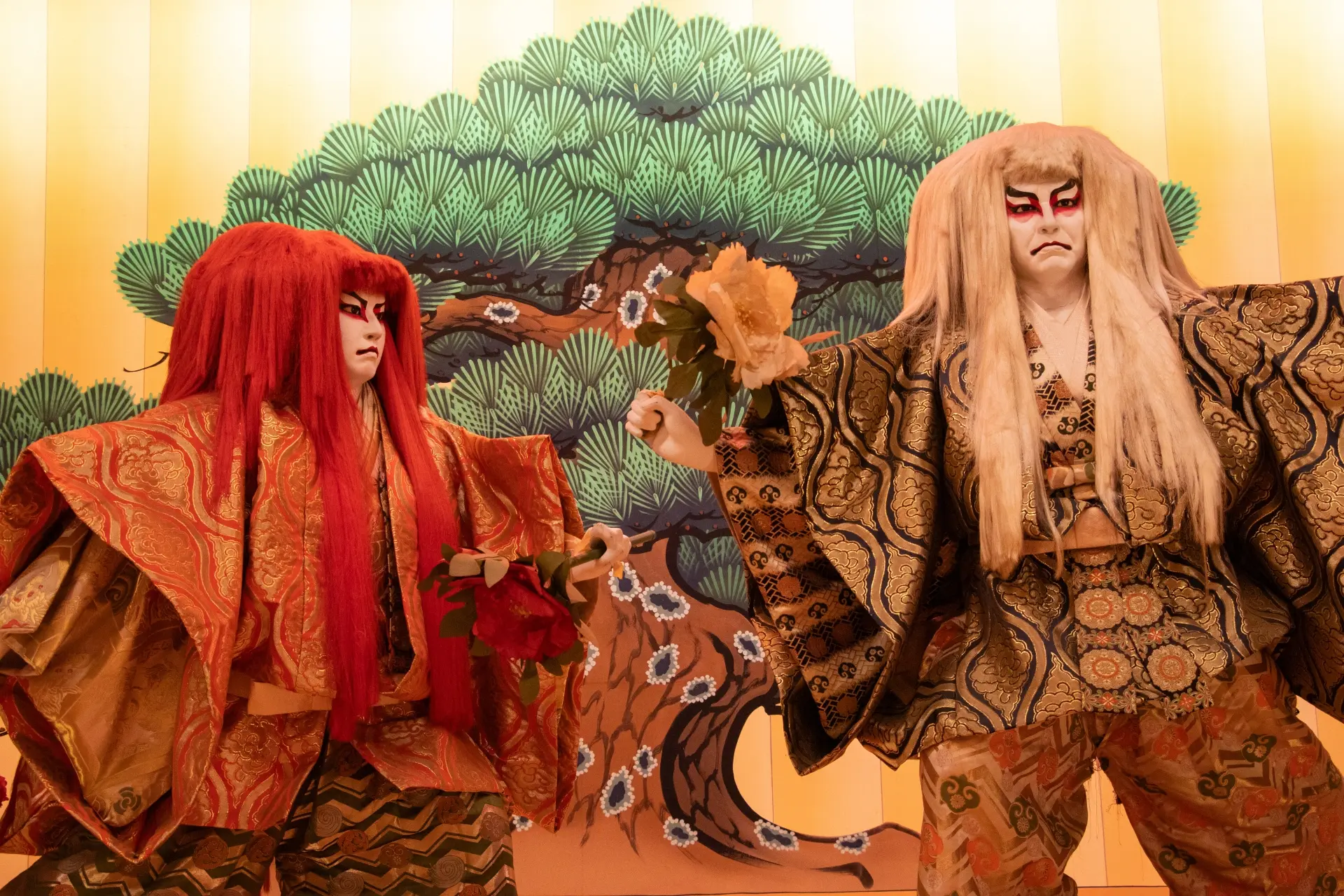 two men in traditional costumes are standing next to each other in front of a pine tree .