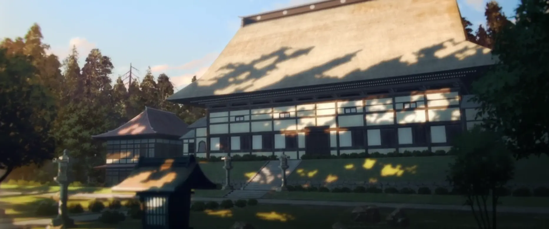 A traditional Japanese building with a large thatched roof in a sunlit garden with a stone lantern.