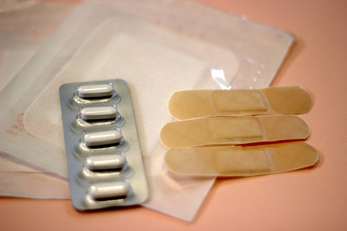 A blister pack of white pills and three adhesive bandages.