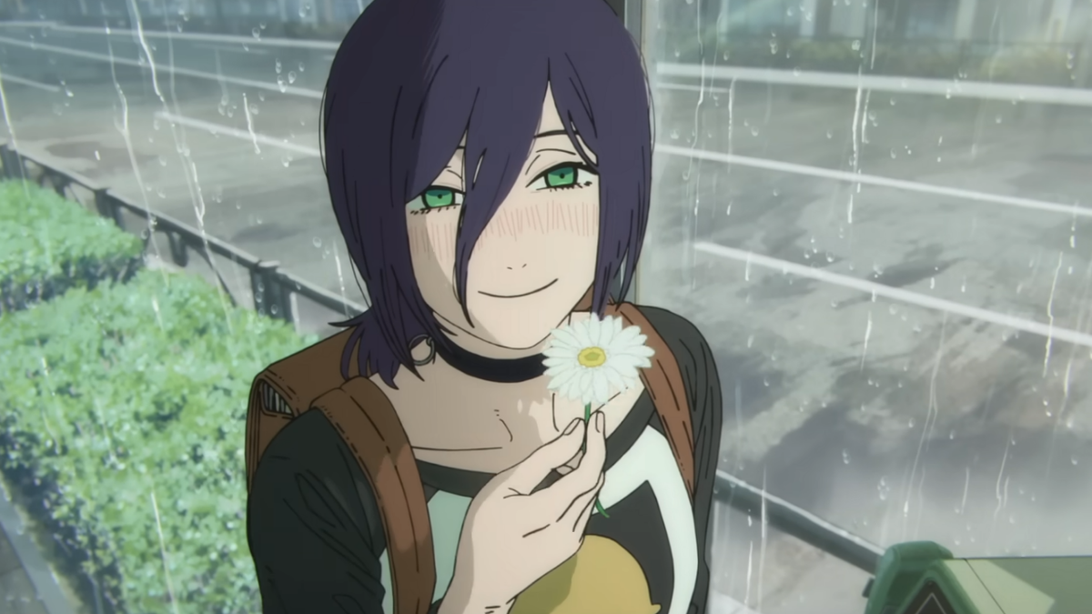 An anime girl with purple hair and green eyes smiles shyly, holding a white daisy in the rain.