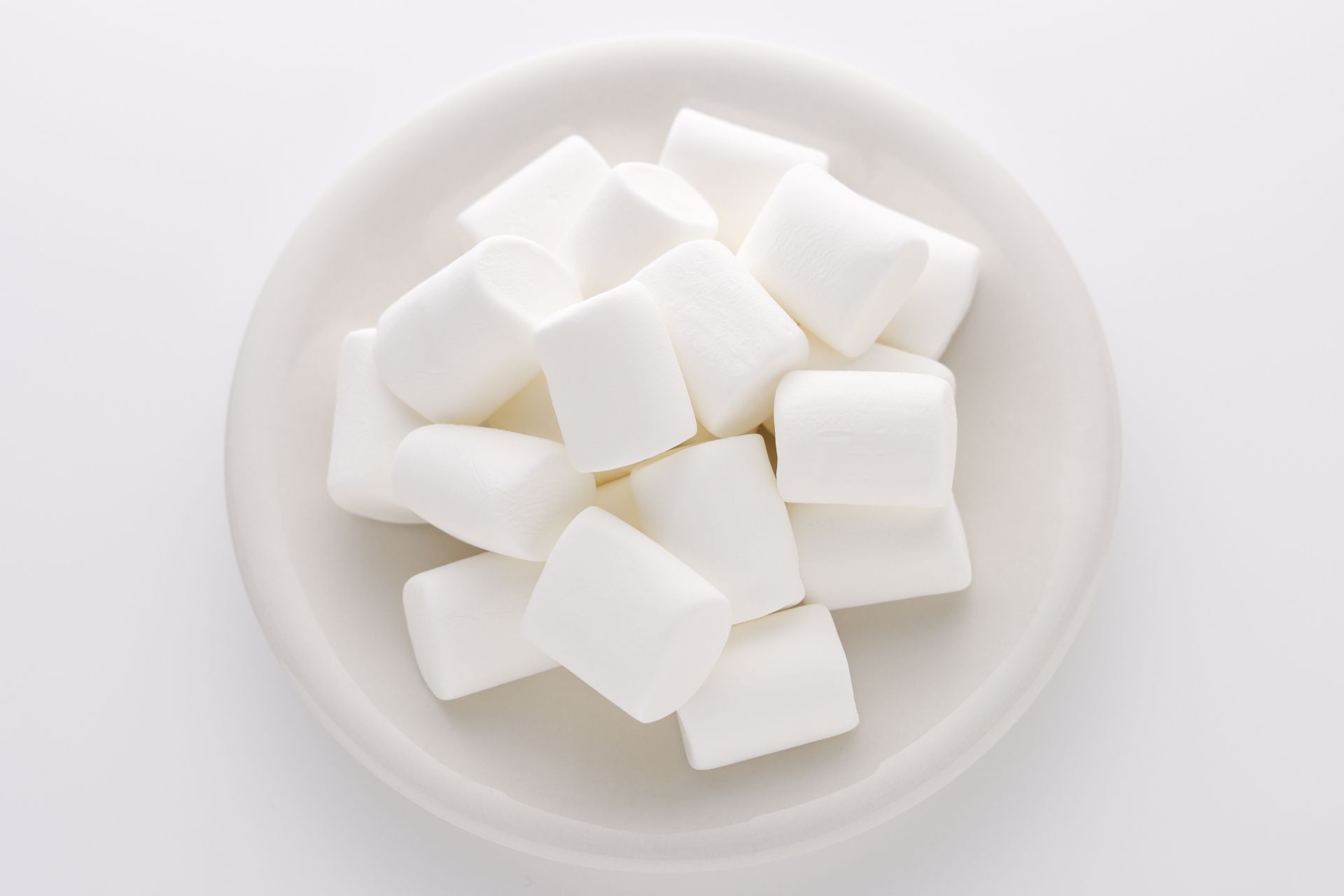White marshmallows on a white plate.