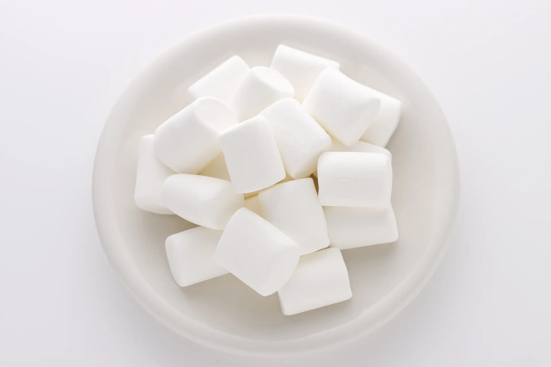 White marshmallows on a white plate.
