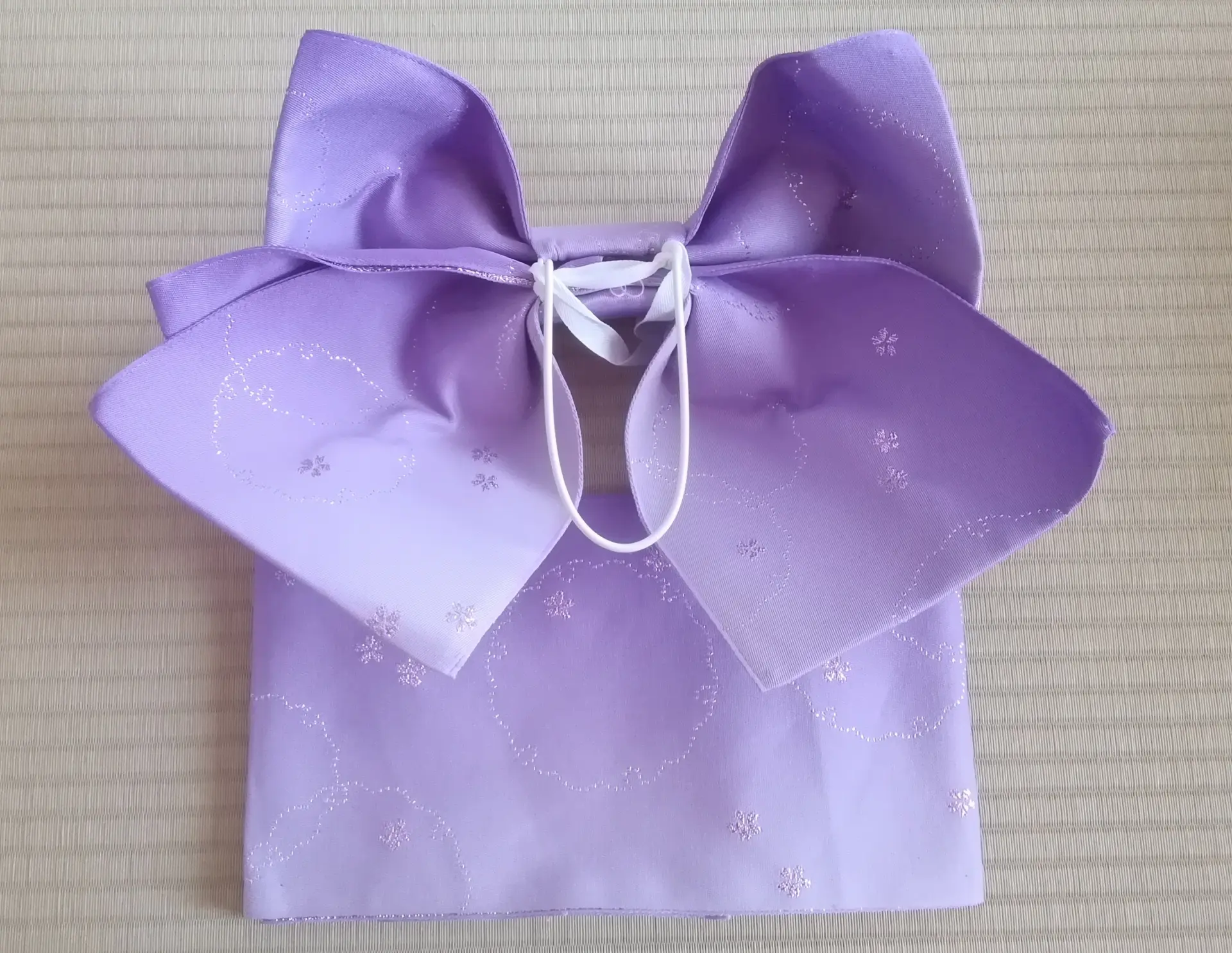 Lavender pre-tied obi with a large bow and subtle glittery floral patterns.
