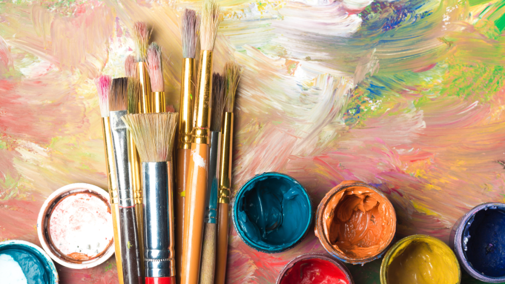 paint brushes and paint tubs on a work of art