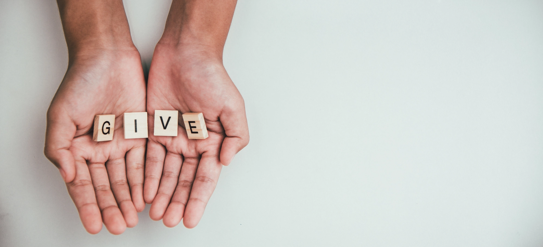 hands hold blocks spelling give