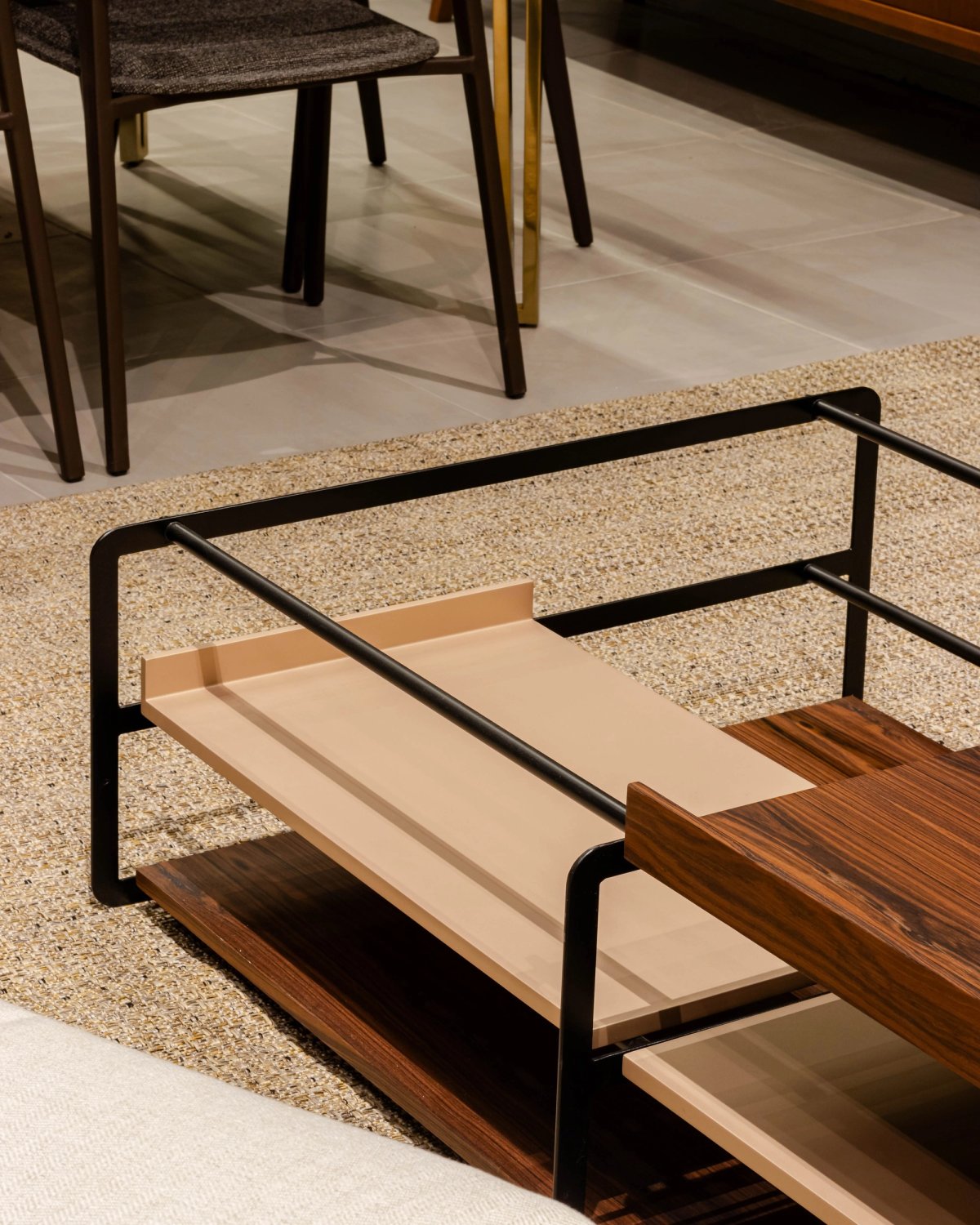 Detalhe de mesa de centro em madeira e metal no showroom.