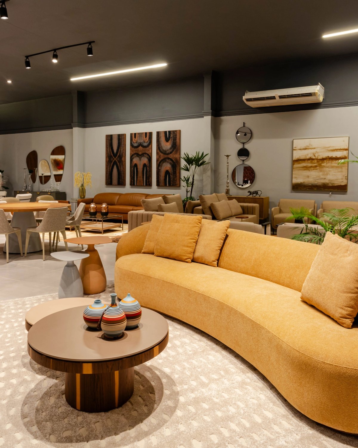 Sofá curvo e mesas de centro no showroom da MS Casa.