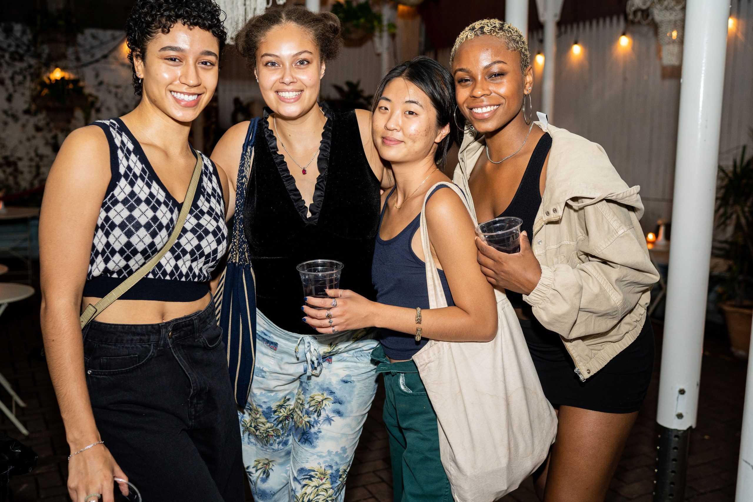 Four friends posing together on the patio