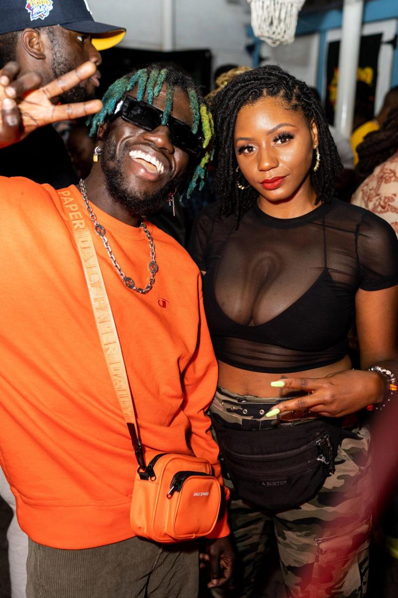 Two guests posing together, one in an orange jacket