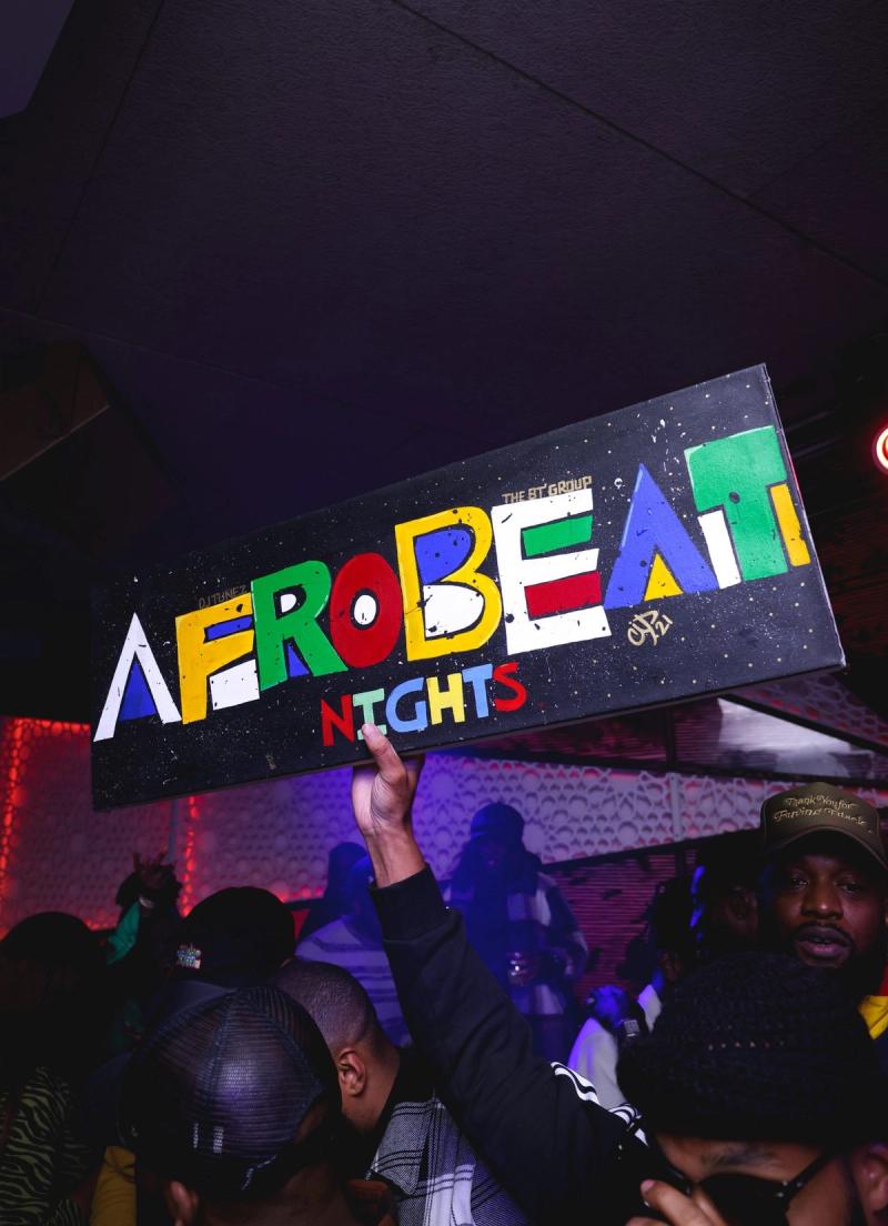 Guests posing by the Afrobeat Nights sign