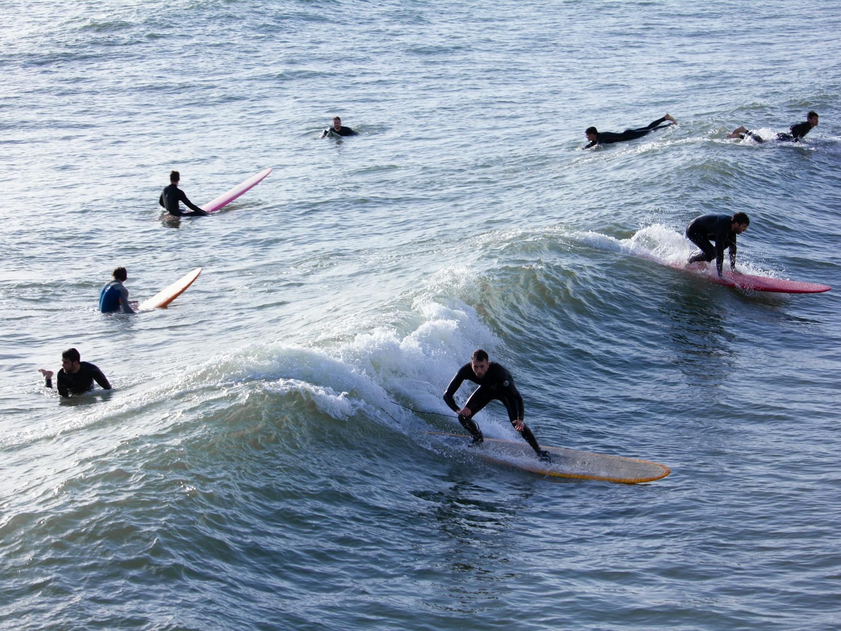 Surfers enjoying ocean waves on a sunny day, capturing the thrill of water sports.