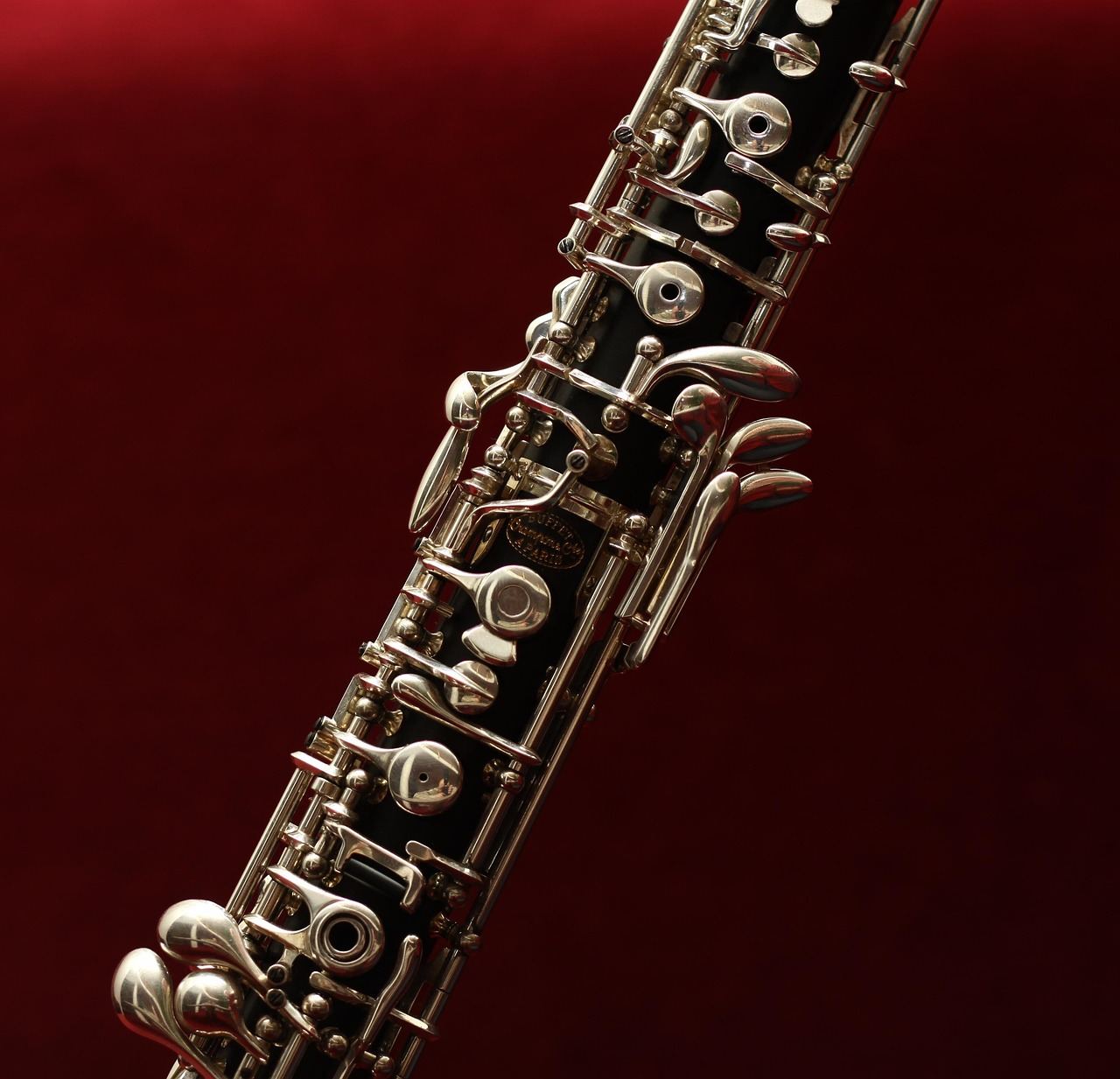 A beautifully crafted wooden oboe rests on a sheet of music, showcasing its elegant design and intricate keywork.