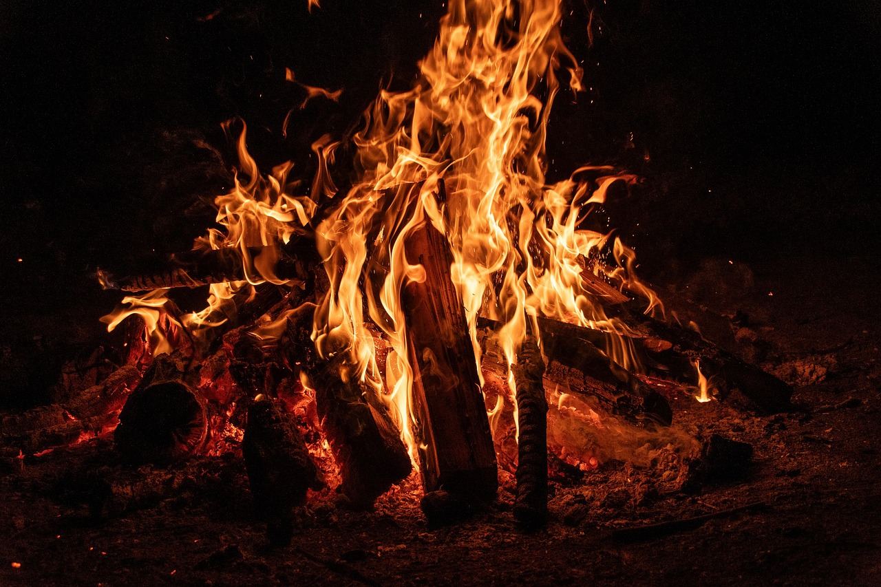A warm campfire crackles under a starlit sky, inviting friends to gather and share captivating stories.