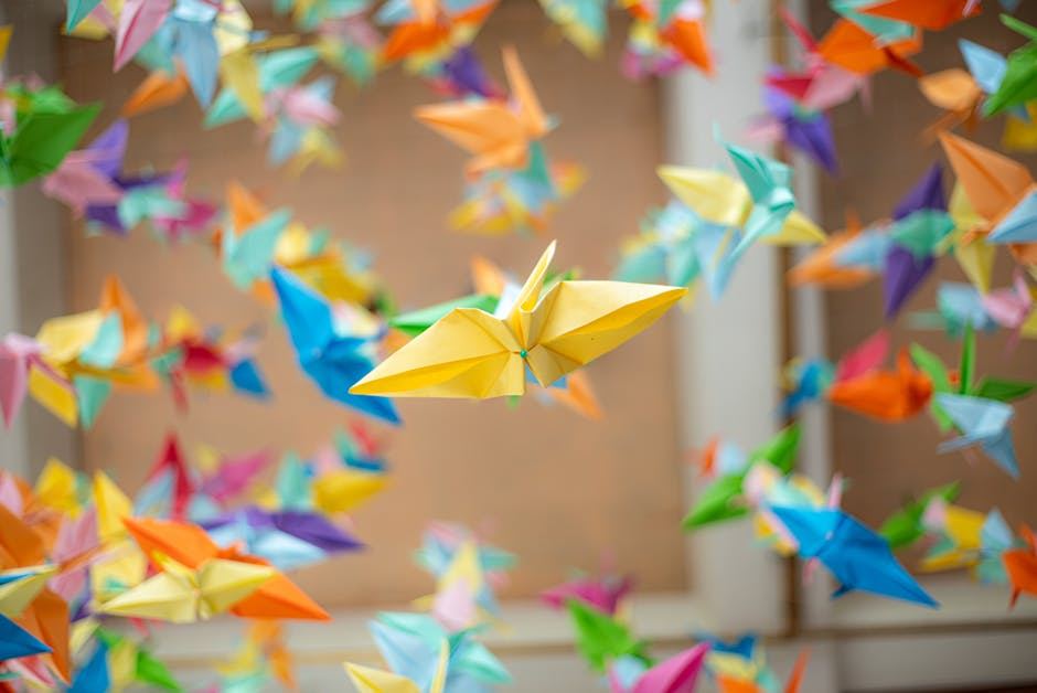 Colorful origami cranes suspended in the air, showcasing the art of paper folding.