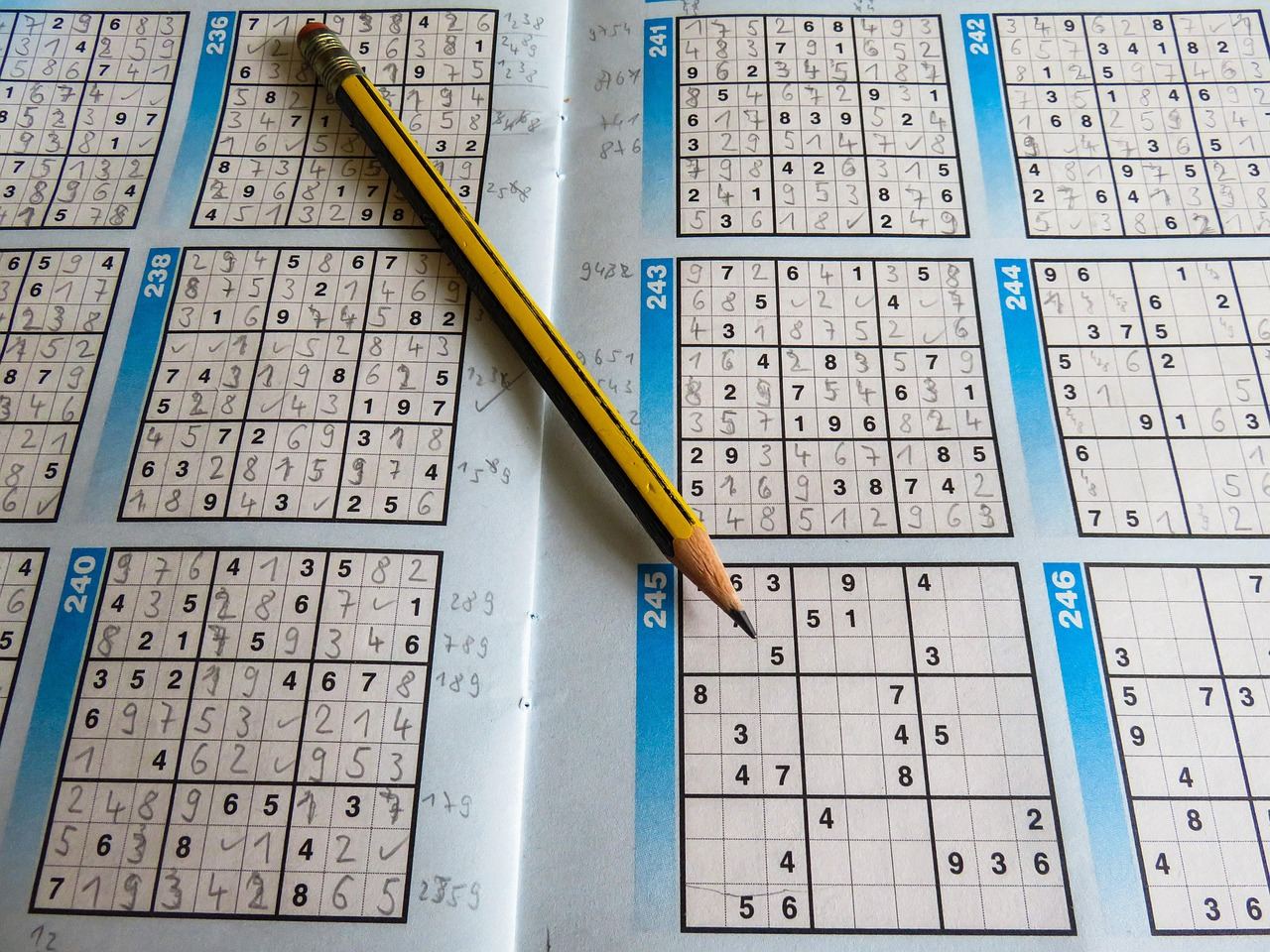 A Sudoku puzzle book with completed grids and a pencil, perfect for 'Is Sudoku for you? Let's find out!'