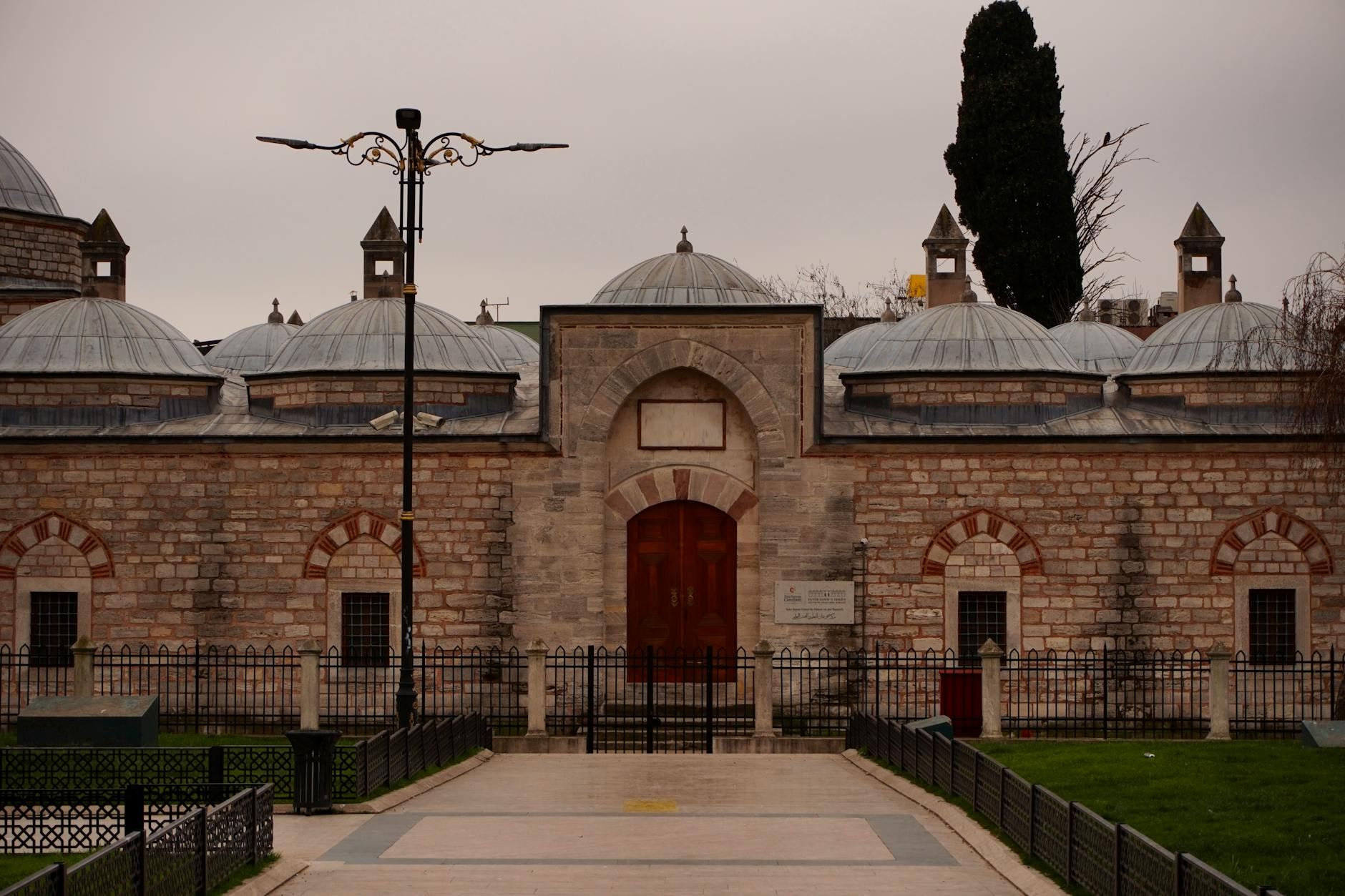 Front view of a traditional Ottoman bathhouse in Istanbul with classic domes and stone facade.