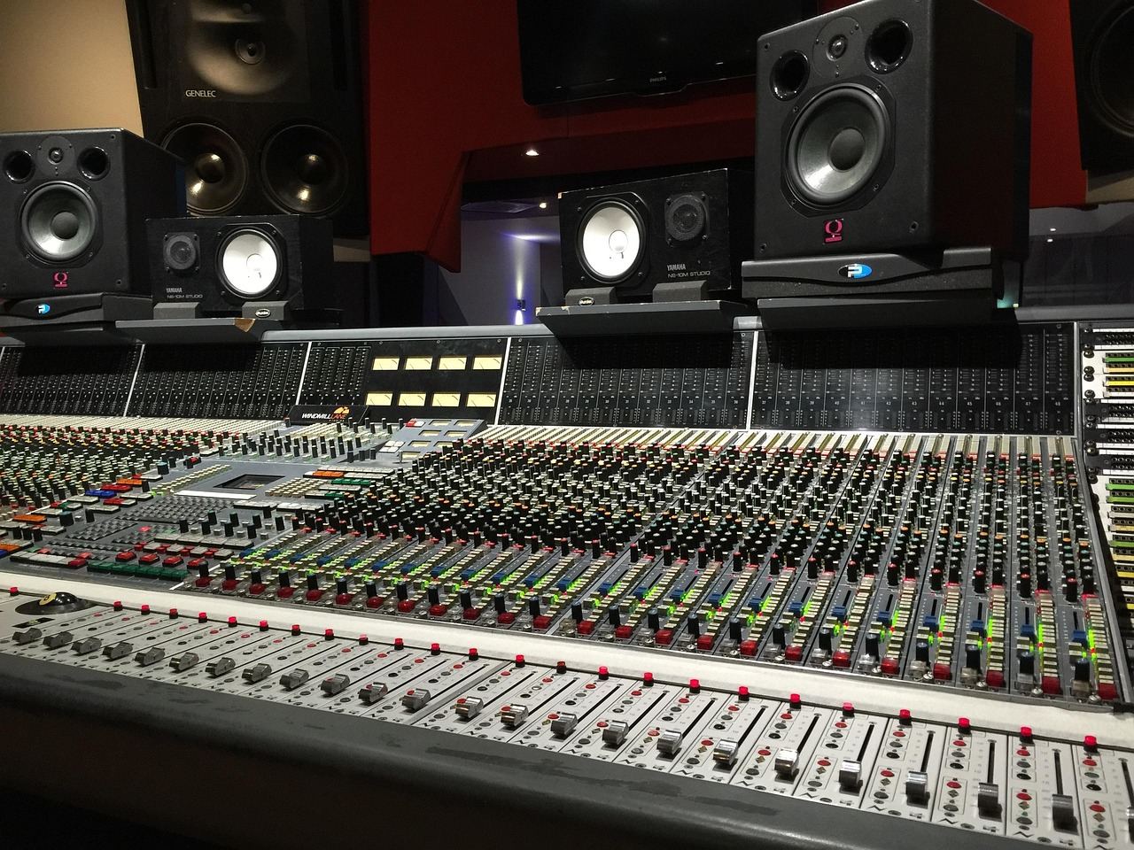 A modern audio studio featuring mixing consoles, microphones, and soundproof walls, creating an inviting atmosphere for sound production.