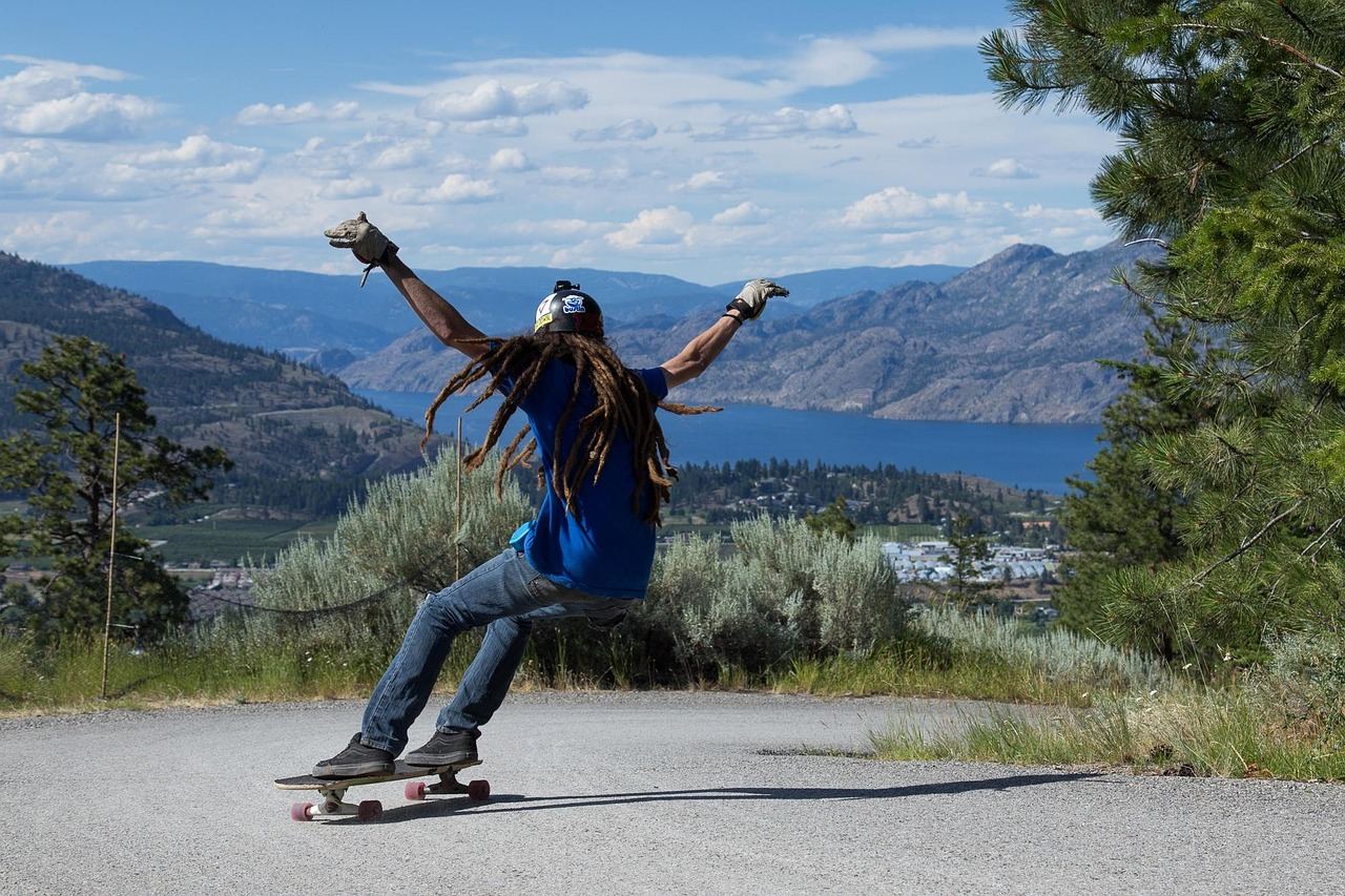 A longboarder rides downhill against a scenic backdrop, embodying the thrill of longboarding. Is Longboarding for you? L