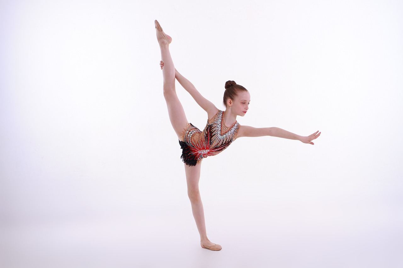 A gymnast gracefully balances on a narrow beam, showcasing strength and poise in a vibrant gym setting.