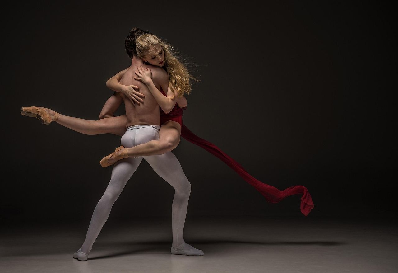 Two dancers engage in a dynamic contemporary dance pose, exploring movement and expression.