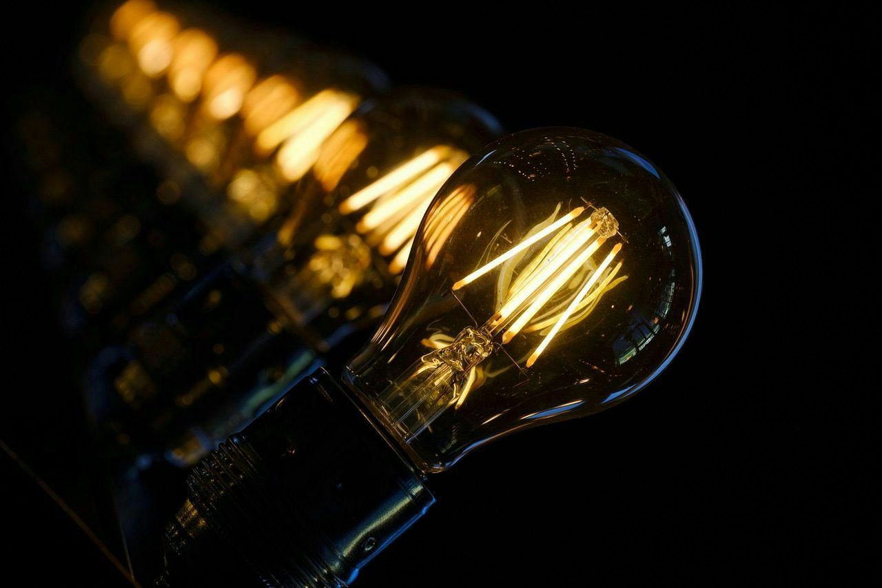 A series of illuminated light bulbs glowing against a dark background, creating a warm ambiance.