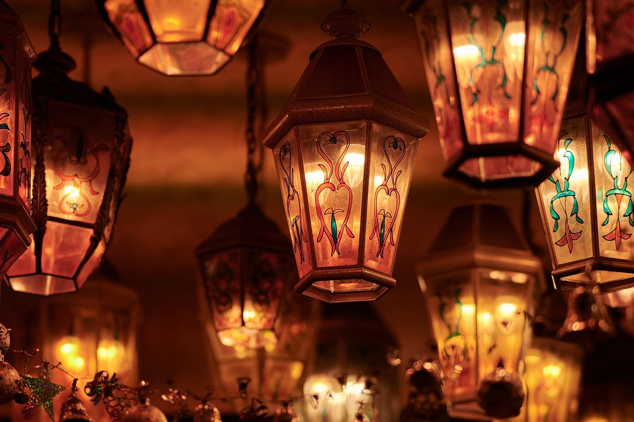 A vibrant lantern glowing brightly against a night sky, surrounded by festive decorations and joyful attendees.