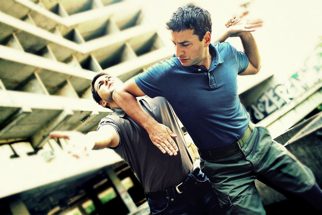 A dynamic scene showcasing individuals practicing Krav Maga techniques, demonstrating strength and agility in a training environment.