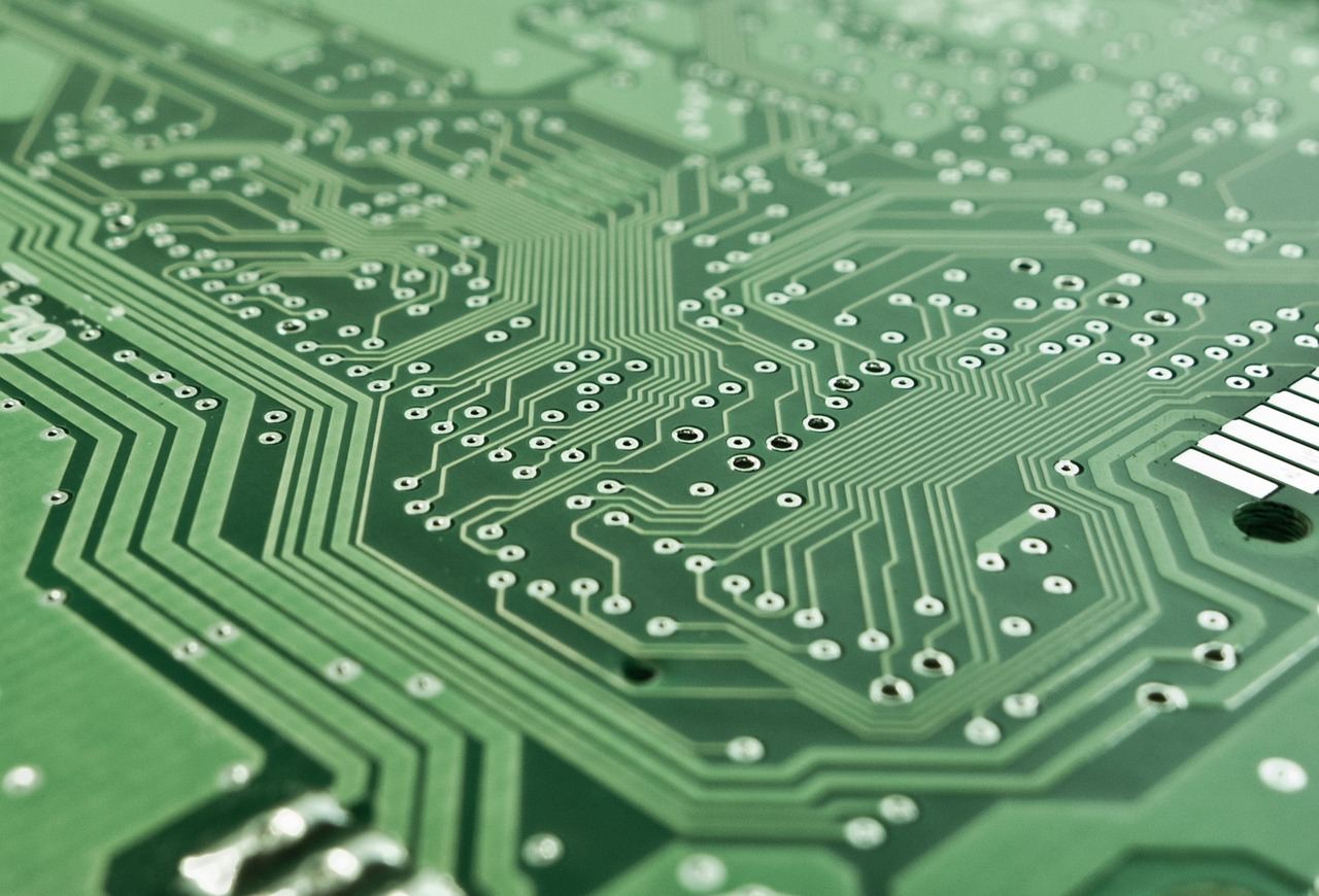 A close-up of a colorful circuit board with various components, wires, and soldered connections, showcasing intricate electronic designs.