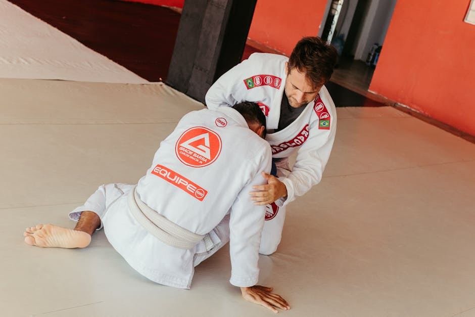 Two practitioners sparring in Brazilian Jiu-Jitsu, showcasing techniques for skill development and fitness.