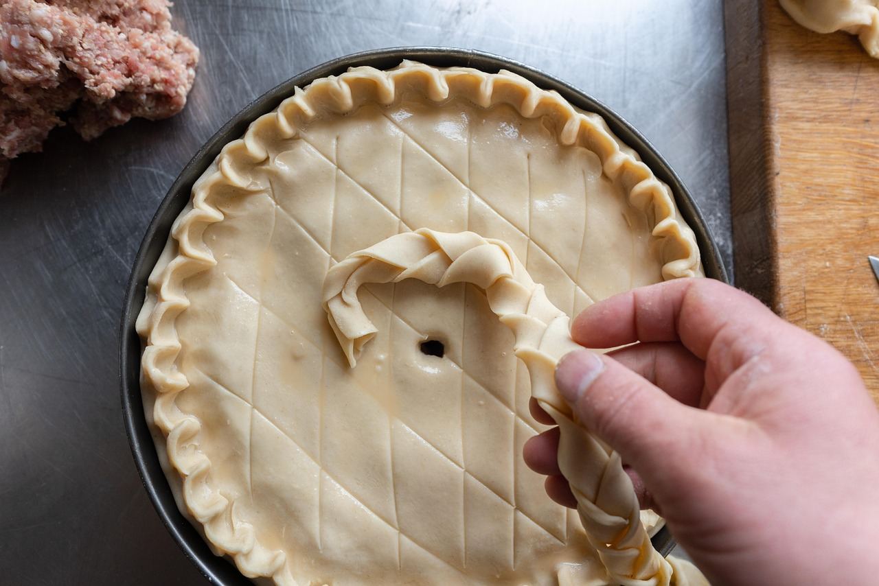 A hand preparing a pie crust, illustrating techniques in pastry baking. Is Pastry Baking for you? Let's find out!