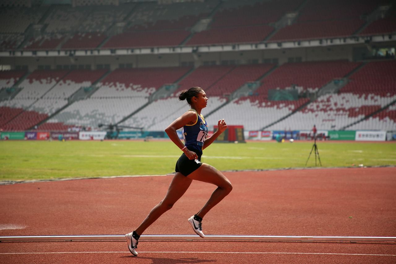 A focused female runner sprints on a track, embodying the spirit of marathon running. Is Marathon Running for you? Let's