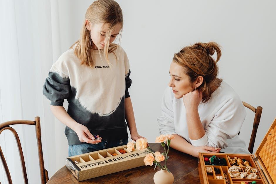A girl and a woman engage with a puzzle box, showcasing interest in the activity.