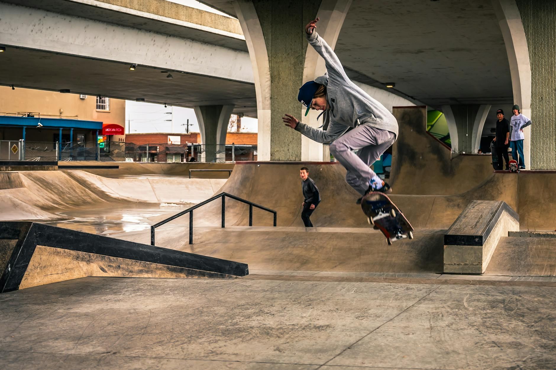 Skilled skateboarder performs a trick in an urban skate park setting, showcasing movement and style.