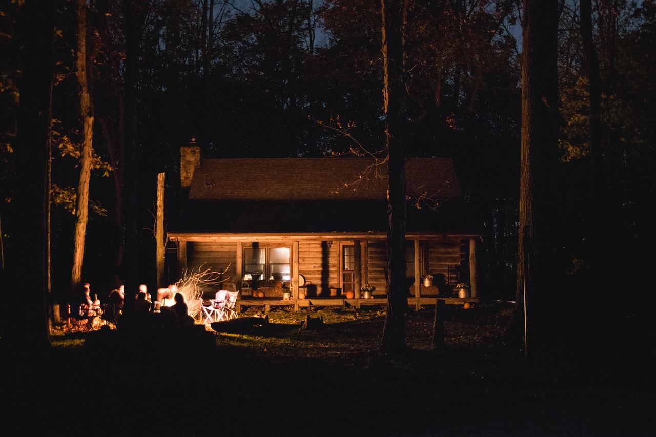 A cozy cabin at night with a fire pit, perfect for exploring fire building techniques. Is Fire Building for you? Let's f