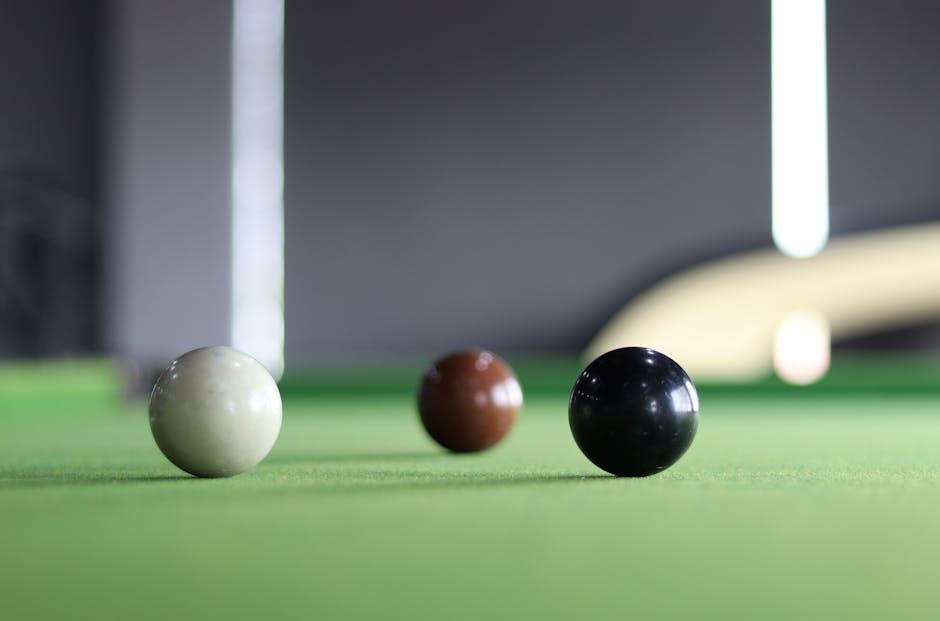 Three snooker balls on a green felt table, suggesting a game of snooker.