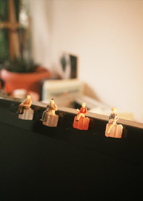 Four miniature figures sitting on the edge of a surface, showcasing the art of figure painting.