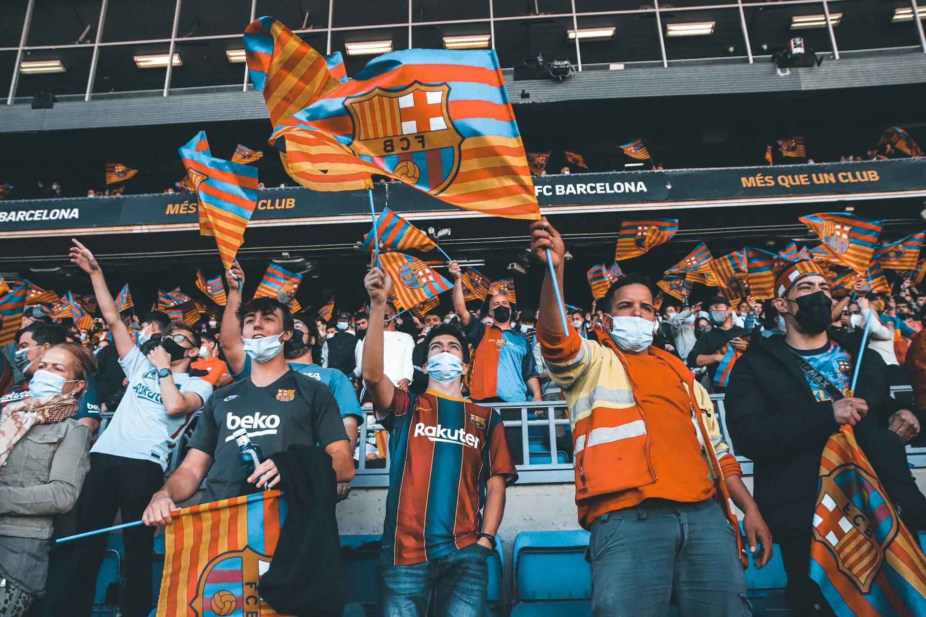 Enthusiastic FC Barcelona fans wave vibrant flags, radiating team spirit and unity during an electrifying football match.