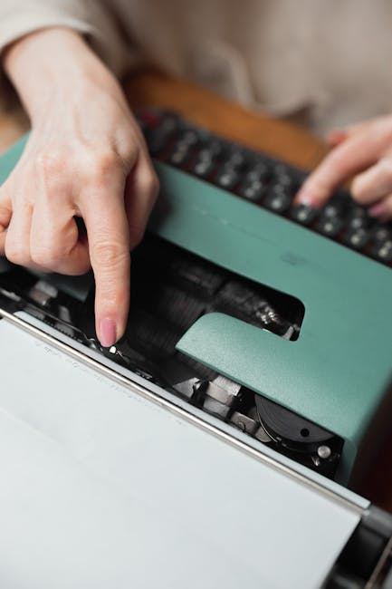 A close-up of a hand typing on a vintage typewriter, suggesting creativity and writing.